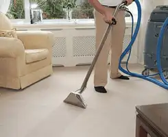 Carpet cleaning professional removing dirt and stains with a hot-water extraction tool in a home, Buffalo, NY.